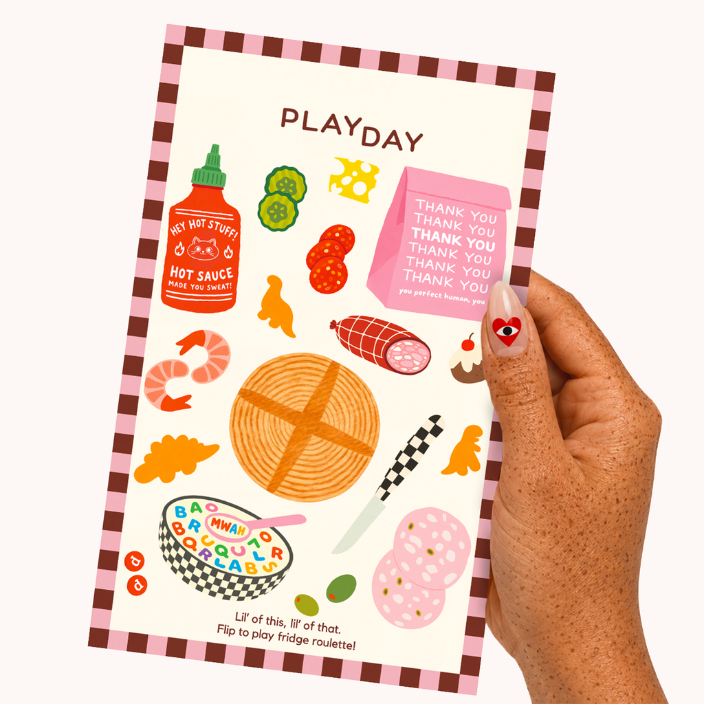 A hand holding a PLAYDAY sticker sheet featuring colorful cartoon food illustrations and text, shown against a plain white background.