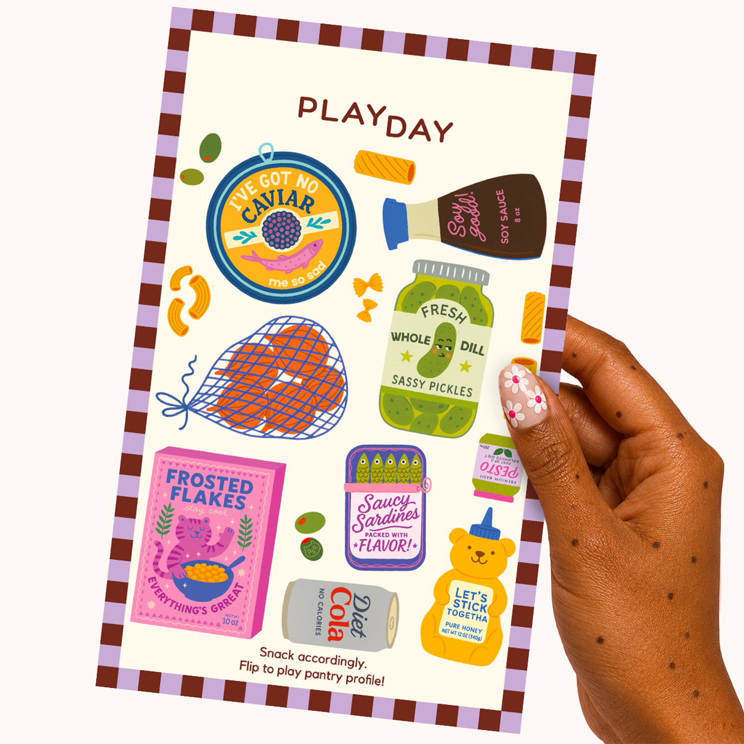A hand holds a sticker sheet titled PLAYDAY with colorful illustrated snack-themed stickers, photographed against a plain light background.