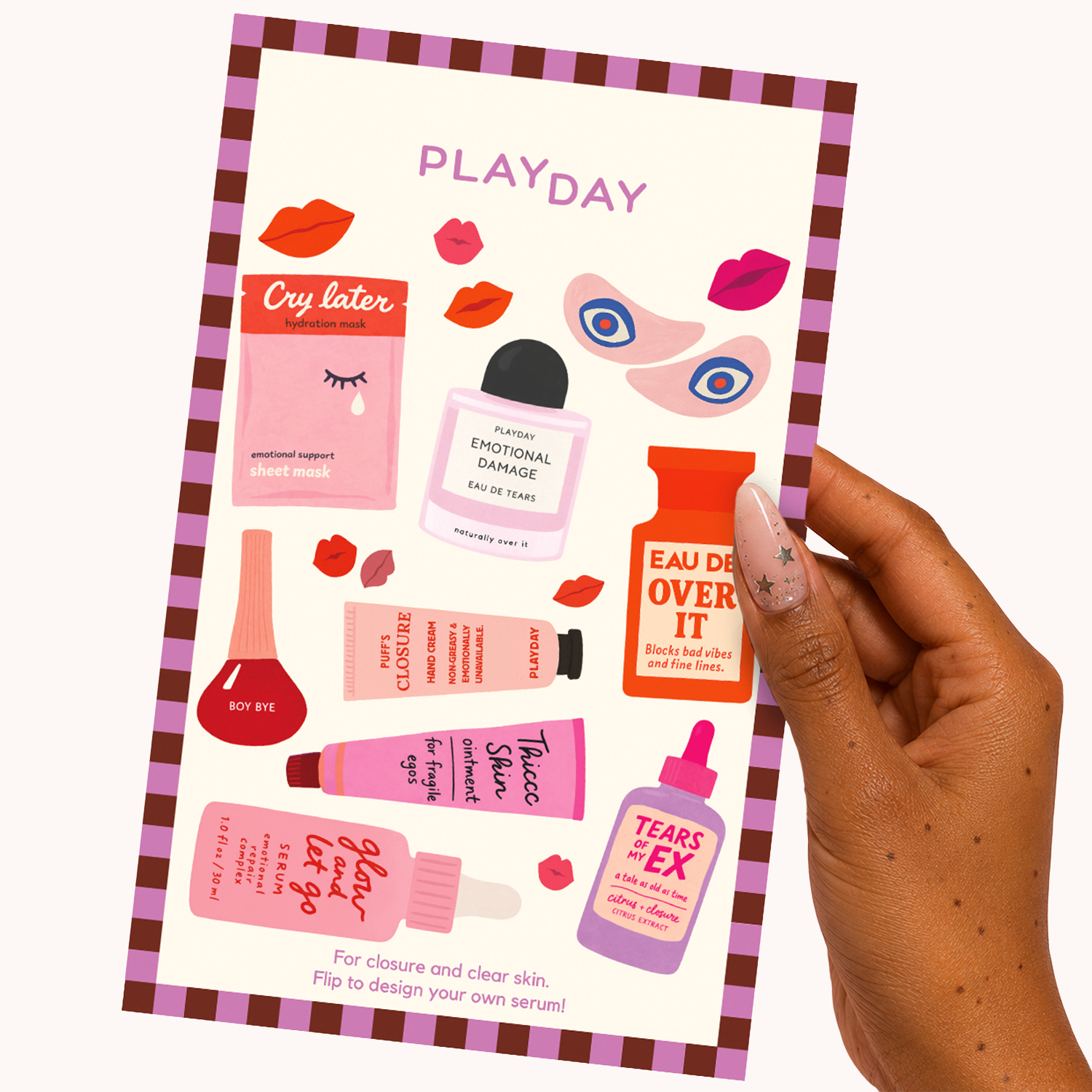 A hand holds a printed sticker sheet, showing illustrated cosmetic-themed graphics and text such as 'Cry later,' 'Emotional Damage,' 'Eau de Over It,' and 'Tears EX.' 