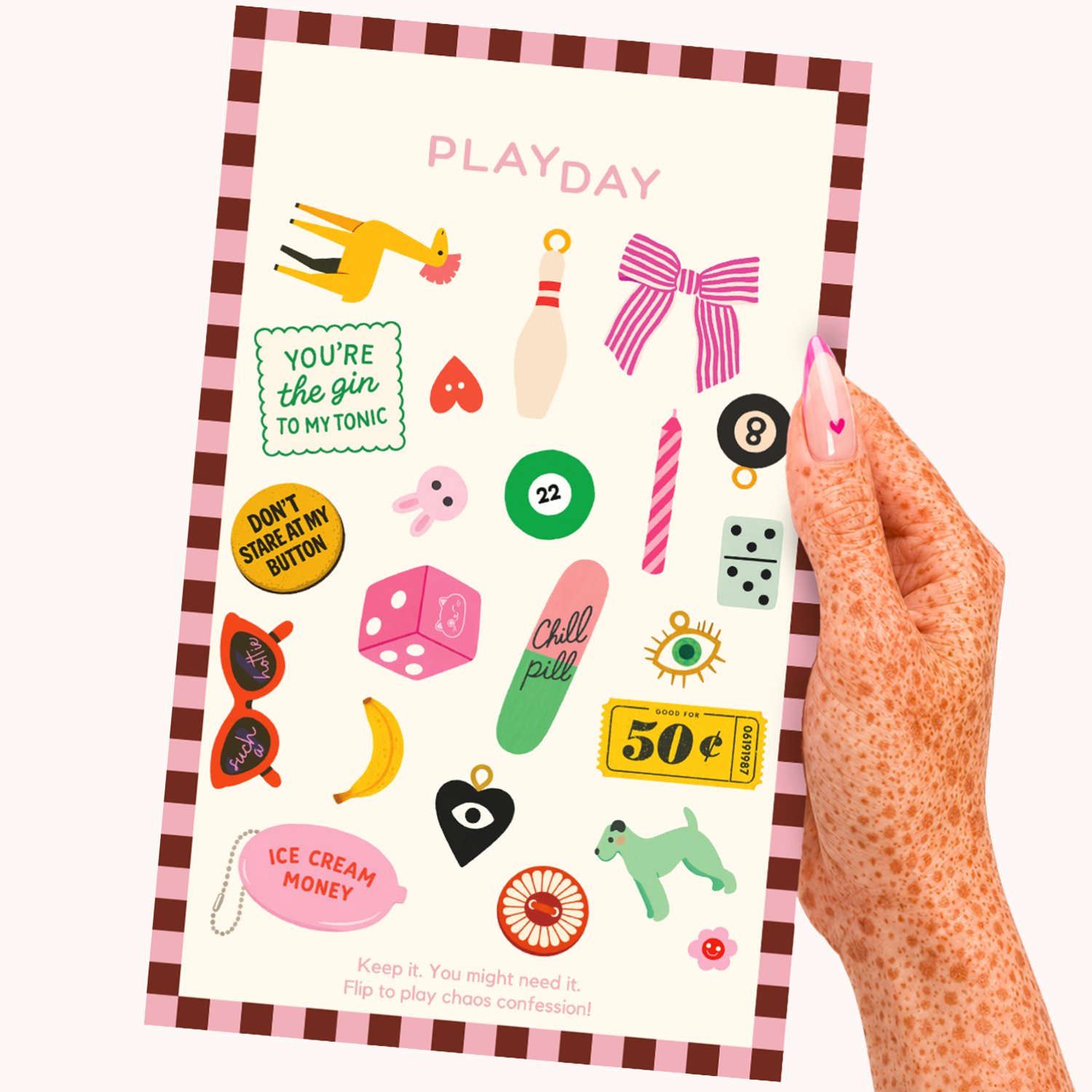 A hand with pink glittery nails holds a Playday sticker sheet. The sheet features a pink and brown checkered border, a cream background, and various colorful playful stickers like a pink bow, green bowling pin, yellow giraffe, and dice.